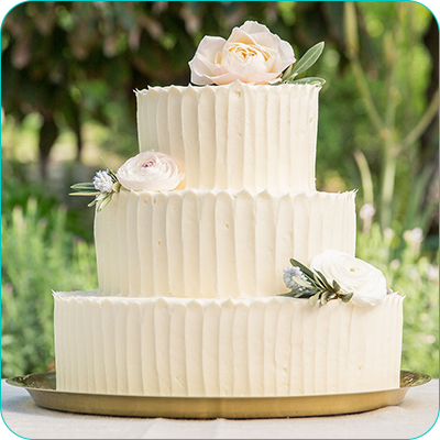 Three tier white wedding cake with flowers